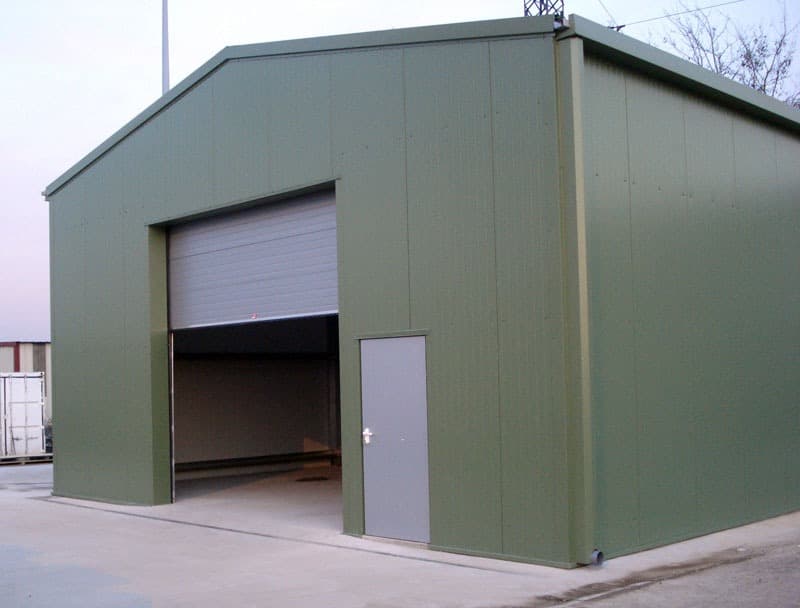 Hangar acier vert avec porte sectionnelle et porte de service